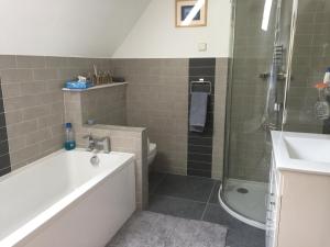 La salle de bains est pourvue d'une baignoire, d'une douche et d'un lavabo. dans l'établissement Martlets B&B, à Shanklin