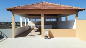 une maison avec un pavillon avec un toit dans l'établissement Appartement familial spacieux avec climatisation, à Ziguinchor