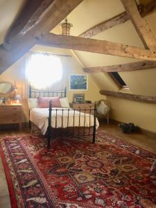 an attic bedroom with a bed and a rug at Lower House Farm B&B, Herefordshire in Hergest