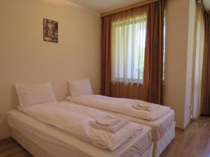 two beds in a room with a window at Rivendell Apartments Borovets Gardens complex in Borovets