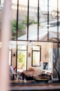 a dining room with a table and chairs and windows at Maison de charme d'Arles in Arles