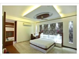 ein Schlafzimmer mit einem weißen Bett in einem Zimmer in der Unterkunft SM Palace (Near Apollo Hospital) in Neu-Delhi