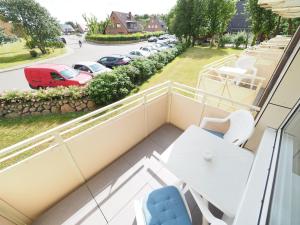 einen Balkon mit einem Tisch und Stühlen sowie einen Parkplatz in der Unterkunft Appartement 6 in Westerland