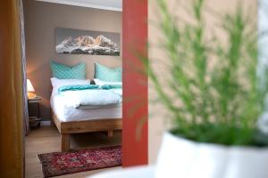 een slaapkamer met een bed en een vaas met een plant bij CasaKarita in Forstern