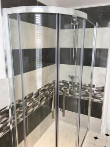 y baño con ducha y puertas de cristal. en The Snowdon House, en Shanklin
