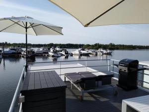 - un quai avec une table, un parasol et des bateaux dans l'établissement Hausboot Leukermeer Well, à Well