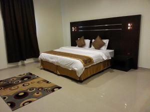 a bedroom with a large bed with a large headboard at Elaf Suits in Abha