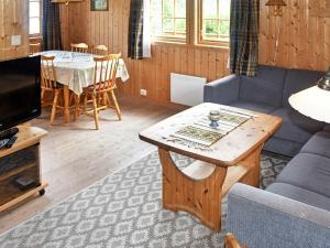 a living room with a couch and a table at Three-Bedroom Holiday home in Utvik 1 in Reed