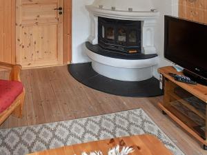 a living room with a fireplace and a tv at Three-Bedroom Holiday home in Utvik 1 in Reed