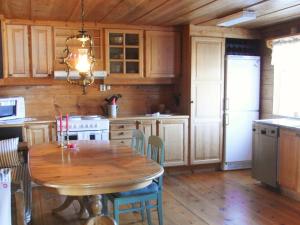 Il comprend une cuisine avec une table en bois et du parquet. dans l'établissement Two-Bedroom Holiday home in Väddö 1, à Veda