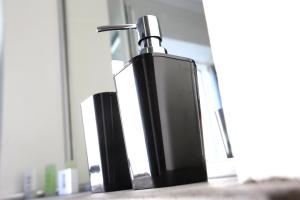 a black soap dispenser sitting on top of a counter at CasaKarita in Forstern