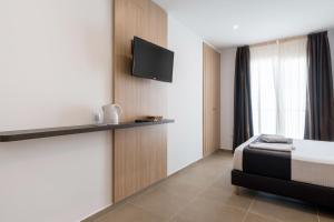 a bedroom with a bed and a tv on a wall at Plaza de la Luz Cádiz in Cádiz