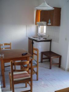 cocina con mesa y sillas y cocina con fregadero en Mertonas Studios, en Karpathos