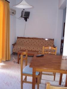 a living room with a table and chairs and a couch at Mertonas Studios in Karpathos