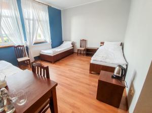 Zimmer mit 2 Betten, einem Tisch und Stühlen in der Unterkunft Missterium Zakliczyn in Zakliczyn
