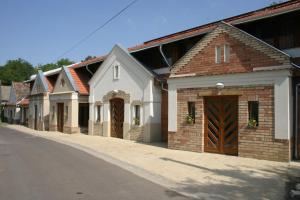 una fila de casas con puertas de madera en una calle en Pincelakat Borház és Szálloda, en Császártöltés