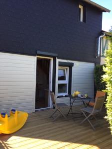 a patio with a table and chairs on a deck at "Le petit Moulinsard" in Bernay