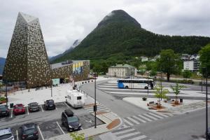 uma cidade com carros estacionados num parque de estacionamento com uma montanha em Åndalsnes Sentrum Apartment em Åndalsnes