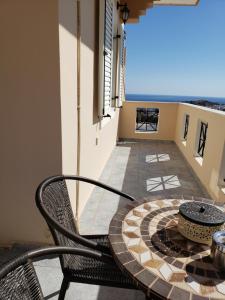 a patio with a table and a chair on a balcony at Damatria studio in Karpathos
