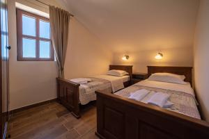 two beds in a room with a window at Villa Old Castle Apartments in Kotor