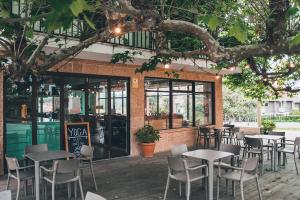 a row of tables and chairs in front of a restaurant at Latas Surf Lodge in Loredo