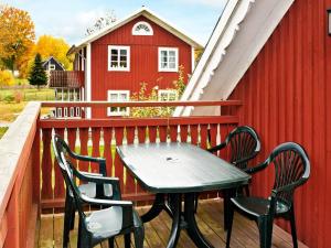 Torne的住宿－Two-Bedroom Holiday home in Lönashult 1，一个带红色谷仓的甲板上的桌椅