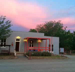 a small white building with a red frame at The Ibis Lounge in Nieu-Bethesda