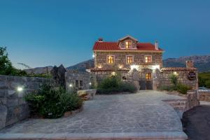 a large stone house with a stone wall at Villa Old Castle Apartments in Kotor