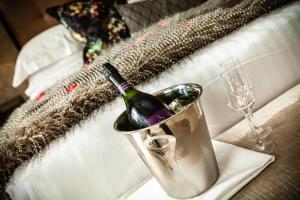 een fles wijn in een emmer op een tafel met een glas bij Nira Caledonia in Edinburgh