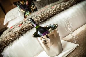 a bottle of wine in a bucket on a table with a glass at Nira Caledonia in Edinburgh