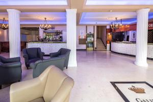 a lobby with chairs and a bar in a building at Hôtel Galilée Windsor in Lourdes