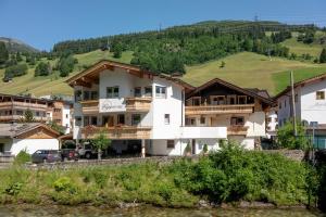 une maison avec une colline en arrière-plan dans l'établissement alpenrose hotel-garni, à Gerlos