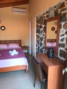 a bedroom with a bed and a desk and a mirror at Villa Makri in Mákri