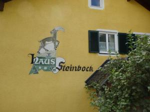 a sign on the side of a yellow building at Apartments Haus Steinbock in Tauplitz