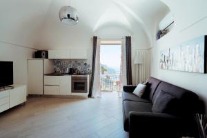 a living room with a couch and a kitchen at Chez Rosa - Cozy sea view openspace - 10mins from Belmond Caruso Ravello in Ravello
