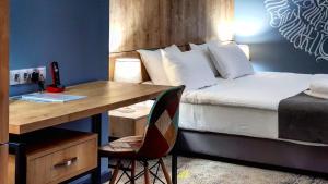 een slaapkamer met een bed en een bureau met een bed gmaxwell gmaxwell gmaxwell gmaxwell bij Hotel Alpha in Jerevan