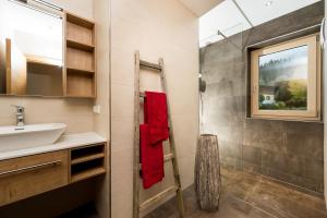 La salle de bains est pourvue d'un lavabo et de serviettes rouges. dans l'établissement Gasthof Hubertus, à Saalfelden