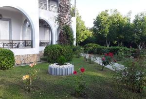 a garden in front of a building with a plant at ARTEMIS Studios & Apartments Sidari in Sidari