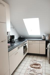 een keuken met witte apparatuur en een tapijt op de vloer bij Ferienwohnung Haus Schmitt in Winterberg