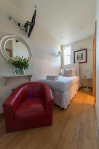 una camera con letto, sedia e specchio di The Paramount Hotel a Londra