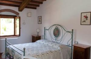 a white bedroom with a bed and a window at Podere i Melograni in Guardistallo