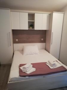 niewielka sypialnia z łóżkiem z białymi szafkami w obiekcie Apartmani Roko w Drveniku