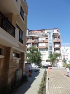 two people walking down a sidewalk in front of buildings at Studio-Pomorie in Pomorie