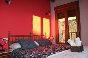 - une chambre avec un lit aux murs rouges et une fenêtre dans l'établissement Nekasenea II, à Garísoain