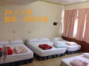池上郷にあるChishang Pumpkin Homestayのベッド3台 ベッド1台 壁掛け