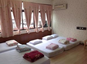 two twin beds in a room with windows at Chishang Nangua Homestay in Chishang