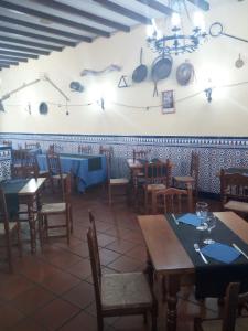 a dining room with tables and chairs and utensils on the wall at La Posada de Eustaquio in Canjáyar