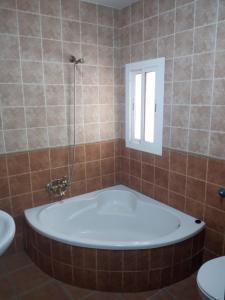 a bath tub in a bathroom with a window at La Posada de Eustaquio in Canjáyar
