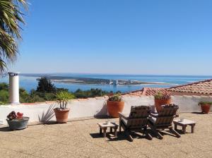 a patio with two chairs and a view of the ocean at Moinho do Marco in Setúbal