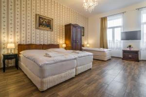 a bedroom with two beds and a chandelier at RETRO Apartments Bosak in Prešov